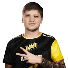 a man wearing a black and yellow shirt that says navi