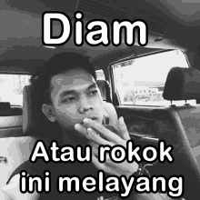 a man smoking a cigarette in a car with the words diam atau rokok ini melayang