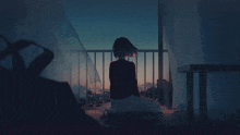 a girl is sitting on the floor on a balcony looking out at the city at night .