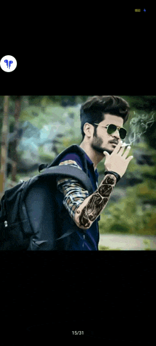 a man smoking a cigarette with a tattoo on his arm