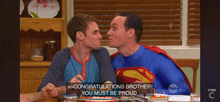 two men in superman costumes congratulate each other