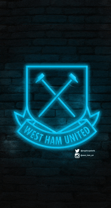 a glowing logo for west ham united is on a dark brick wall