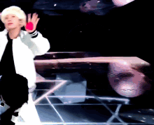 a man in a white jacket is dancing on a stage with a pink object in his hand