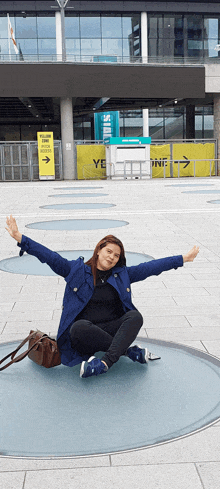 a woman sitting on the ground with her arms outstretched in front of a sign that says ' yes zone '