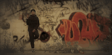 a man stands in front of a wall with graffiti on it including the letters r and t