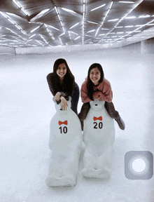 two girls are riding on the backs of a polar bear with the number 20 on it