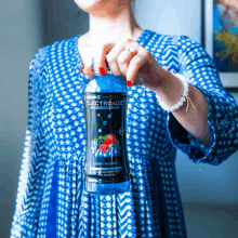 a woman holds up a bottle of electroade berry smashed