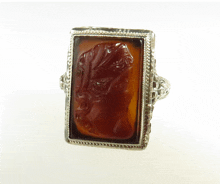 a silver ring with a carved stone in the middle