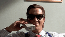 a man wearing sunglasses is talking on a cellphone