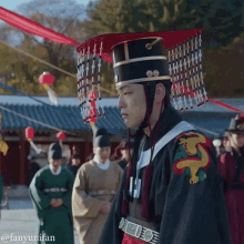 a man in a traditional costume stands in front of a group of people with the caption fanyunifan on the bottom