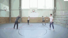 a group of people are playing a game of basketball in a gym with a basketball hoop in the background