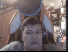 a man wearing headphones is making a funny face while sitting in a chair