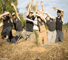 a group of people are posing for a picture with their hands in the air and their shirts say 2