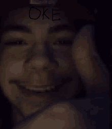 a blurry picture of a man 's face with the word oke written on it