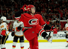 a hockey player in a red and black uniform with a large c on his chest