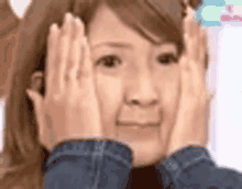 a woman is making a funny face with her hands covering her face .