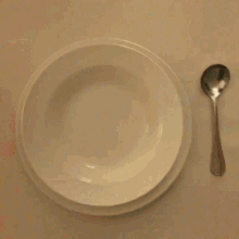 a bowl of cereal sits on a table with a window in the background