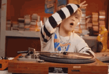 a boy is playing a record on a turntable that says jewel