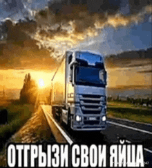 a truck is driving down a highway at sunset with russian writing on it .