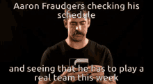 aaron fraudgers checking his schedule and seeing that he has to play a real team this week with a man holding a cell phone