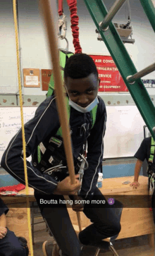 a boy wearing a mask is hanging from a rope in front of a sign that says air conditioning