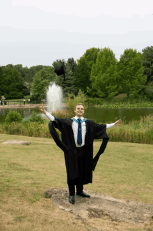 a man wearing a graduation cap and gown throws his cap in the air