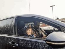 a man and a child are sitting in a car and the child is smiling