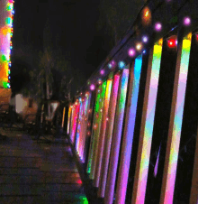 a row of colorful lights are lined up on a fence