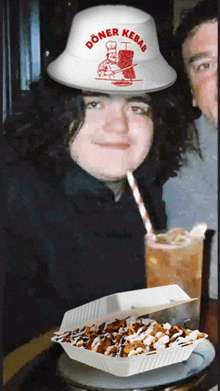 a man wearing a doner kebab hat drinks from a cup