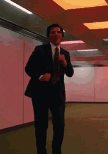 a man in a suit and tie is running in a hallway