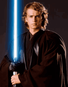 a young man in a black robe holds a light saber