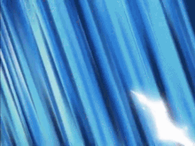 a close up of a blue curtain with a light shining through it .