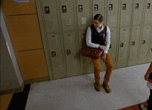 a man sits on the floor in front of a row of lockers with the letters aa on the front