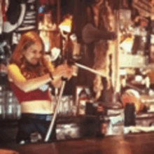 a woman is standing behind a bar making a drink with a straw .