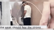 a man is urinating in a urinal with a caption that says ' the weak should fear the strong '