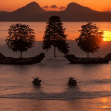 three boats are in the water at sunset