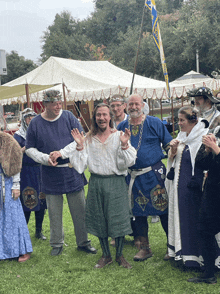 a group of people dressed in medieval costumes are standing in a field