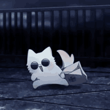 a small white cat wearing sunglasses is walking on a wooden floor .