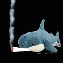 a stuffed shark is smoking a red cigarette