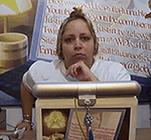 a woman is sitting at a desk in front of a sign that says ' youth ' on it .