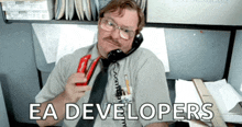 a man talking on a phone with the words " ea developers " on the bottom