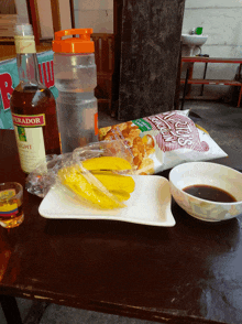 a bottle of negrador light sits on a table next to a bowl of sauce