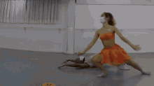 a woman in a red dress is doing a handstand