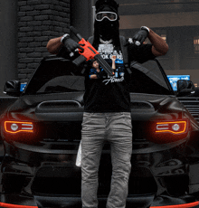 a man holding a gun in front of a black car with a shirt that says america