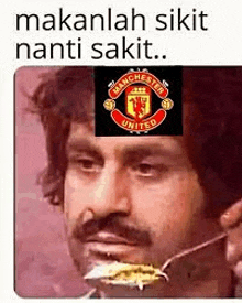 a man with a mustache is eating food with a fork with a manchester united logo on his face .