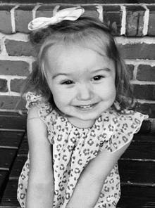 a little girl in a leopard print dress is smiling for the camera