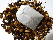 a bag of tea is sitting on top of a pile of dried fruits