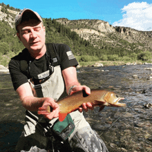 a man holding a fish that says rolex on his shirt