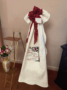 a white quilt with a red and black checkered bow has the words " believe " on it