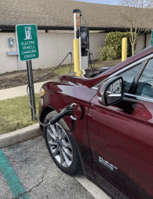 an electric vehicle charging station with a red car plugged in